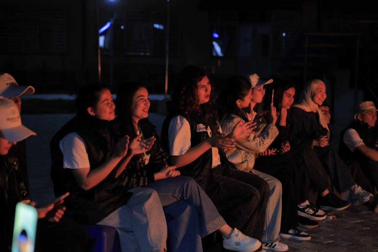 A row of participants applauding during an evening session